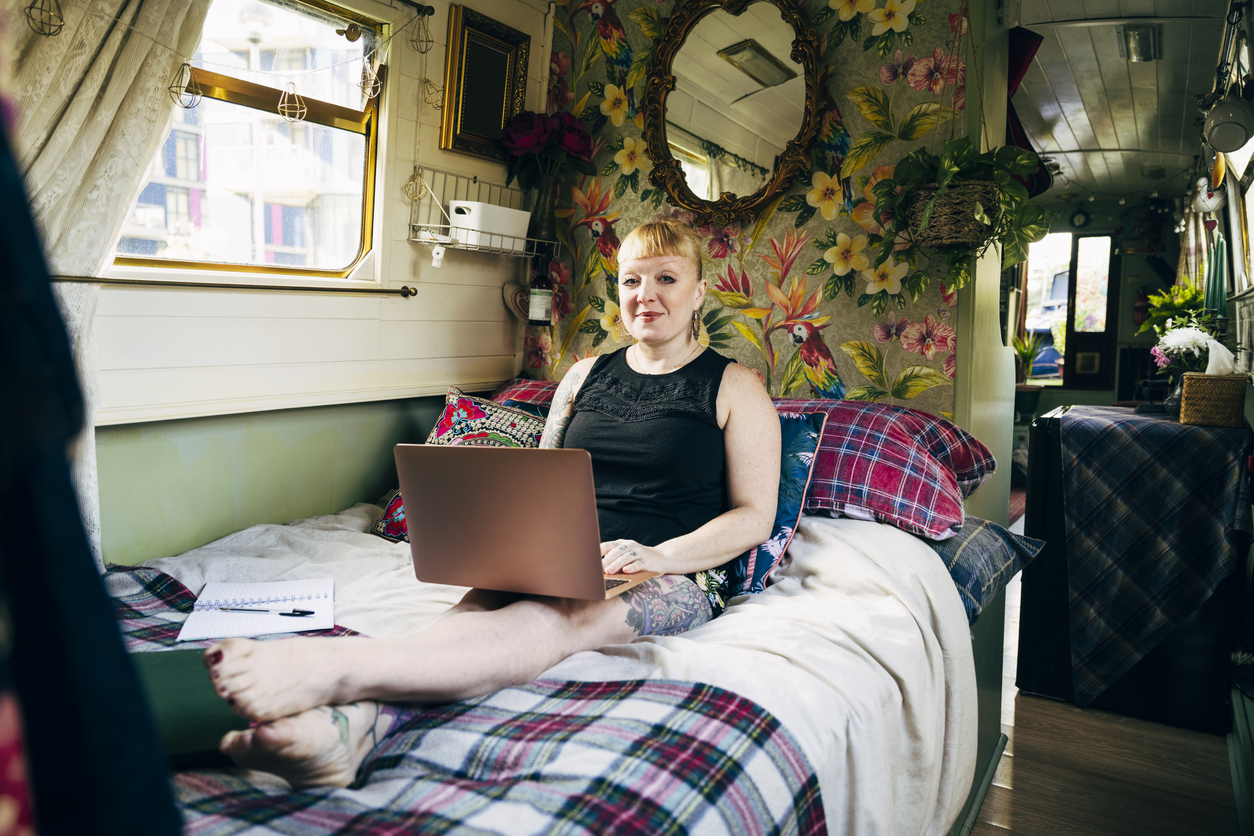 Lady watching tv in bed on her narrowboat